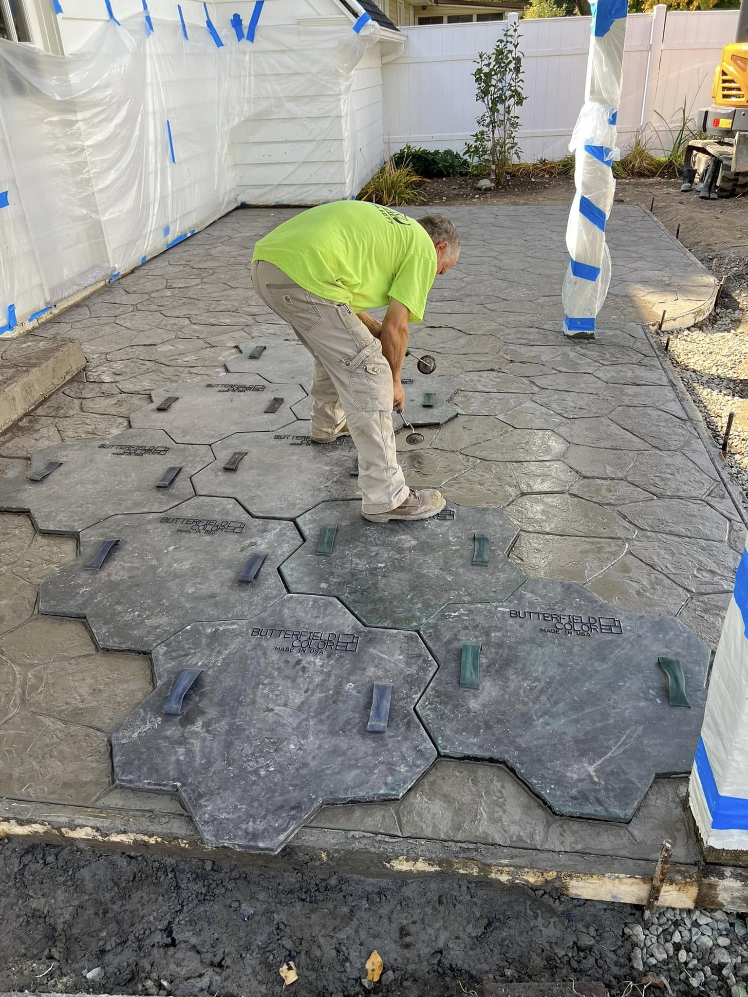 Husky Enterprises crew member stamping a concrete patio